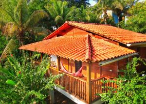 een klein huis met een oranje tegeldak bij Pousada Horizonte Azul in Ilha de Boipeba
