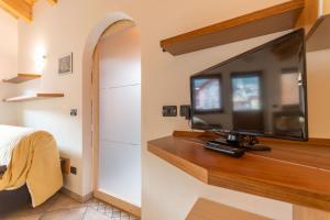 a bedroom with a flat screen tv on a wall at Casa Sartori in Pozza di Fassa