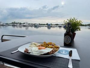 a plate of food on a table with a bottle of beer at Hausboot Buddy in Weyhe