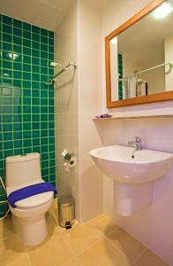 a bathroom with a toilet and a sink at Holidays Home in Pattaya South