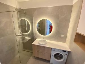 a bathroom with a washing machine and a mirror at Apartament GABA-NIECHORZE przy plaży in Niechorze