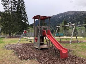a playground with a red slide in a park at Apartment HUGO in Bad Kleinkirchheim