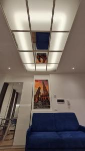 a living room with a blue couch and a ceiling at Giudei House Loft 2 in Bologna