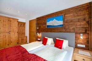 Schlafzimmer mit einem Bett mit roten und weißen Kissen in der Unterkunft Zangerlehof in Slingia