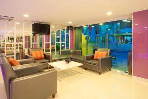 a room with chairs and a table and a tv at Holidays Home in Pattaya South