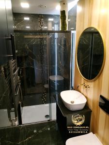 a bathroom with a shower and a sink and a mirror at "Nad Zdrojami" Pokoje Kowalczyk 691-739-603 in Szczawnica