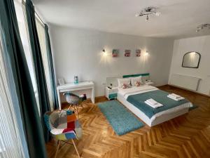 Un dormitorio con una cama, un escritorio y una silla. en 36 Central Residence, en Brasov