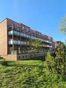 a building with a grassy field in front of it at Rietumkrasta seaside apartment in Liepāja
