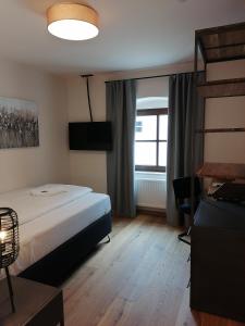 a hotel room with a bed and a window at Hotelgasthof Kirchenwirt in Schierling