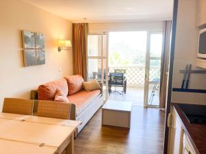 a living room with a couch and a balcony at Residence Cap Esterel Babou in Saint-Raphaël