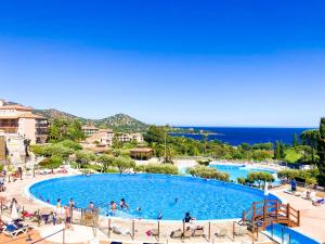 a large swimming pool with people in a resort at Residence Cap Esterel Babou in Saint-Raphaël