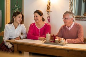 un grupo de tres personas sentadas en una mesa en Bed & Breakfast Hotel Guggis, en Zürs am Arlberg