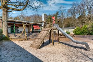 Un parque infantil con un tobogán frente a un edificio. en Stayokay Hostel Apeldoorn, en Apeldoorn