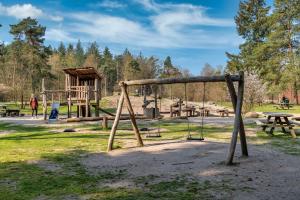 a playground in a park with a swing at Stayokay Hostel Apeldoorn in Apeldoorn