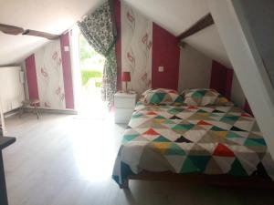 a bedroom with a bed with a colorful quilt at LA CAMPAGNETTE in Canteloup