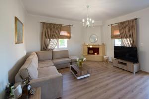 a living room with a couch and a flat screen tv at Liovore Apartments in Lygia