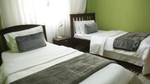 um quarto com 2 camas e uma janela em MAMIKKI Hotel Apartments em Tororo