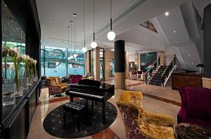 uma sala de estar com um piano e algumas cadeiras em The Savoy Hotel em Limerick