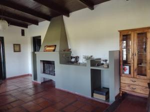 a living room with a fireplace and a wooden cabinet at Hospedaje El Rincon in San Antonio de Areco