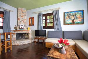 a living room with a couch and a fireplace at Angel Suite in Patitiri