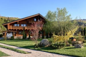 a log cabin with a porch and a pathway leading to it at Pensiunea Varvara de Bucovina in Gura Humorului