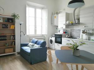 ein Wohnzimmer mit einem blauen Sofa und einem Tisch in der Unterkunft Casa Sansevera Lucca in Lucca