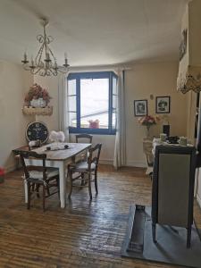 d'une salle à manger avec une table, des chaises et une fenêtre. dans l'établissement Chambres d'hôtes Chez Valérie, à Arette