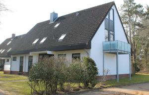 ein weißes Haus mit schwarzem Dach in der Unterkunft Ferienwohnung Südstrand in Wyk auf Föhr