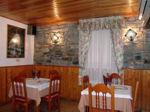 a dining room with two tables and a window at Hostal Pirineos Sarvisé in Sarvisé
