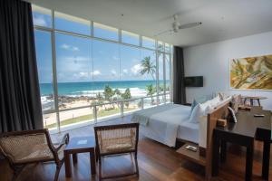 a bedroom with a bed and a view of the ocean at Sielen Diva in Unawatuna