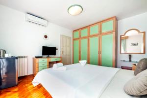 ein Schlafzimmer mit einem großen weißen Bett und einem Fernseher in der Unterkunft Villa Allegria in Rovinj