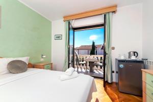 ein Schlafzimmer mit einem Bett und ein Balkon mit einem Tisch in der Unterkunft Villa Allegria in Rovinj + 37 Fotos