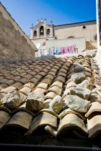 ein altes Kacheldach mit Felsen darüber in der Unterkunft Il Dammuso nel Vicolo in Scicli