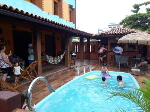 a group of people playing in a swimming pool at Pousada Maravista in Anchieta