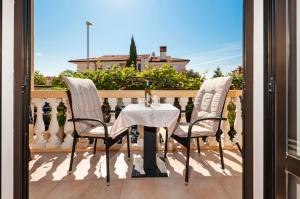 ein Tisch und zwei Stühle auf einem Balkon in der Unterkunft Villa Allegria in Rovinj