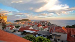 vista su una città con tetti rossi e sull'oceano di Apartments Cava Dubrovnik a Dubrovnik