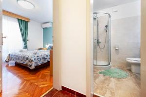 ein Bad mit einer Dusche, einem WC und einem Bett in der Unterkunft Villa Allegria in Rovinj