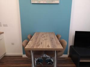 uma mesa de madeira num quarto com uma cadeira em Mandela House Apartments em Kirkcaldy