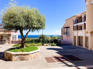 a tree in the middle of a street next to a building at Residence Cap Esterel Babou in Saint-Raphaël