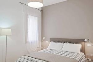 a white bedroom with a bed and a window at enJoy Home - Ampio bilocale nella Padova Antica in Padova