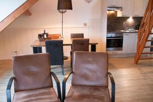 a kitchen with two chairs and a table at Koetsementen appartementen met strandcabine in Domburg