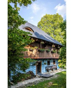 a wooden house with a balcony on the side of it at Modrá chalúpka in Kremnica