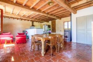 cocina y sala de estar con mesa de madera y sillas en Ecogite Rural La Cle des Champs, en Peyrelongue-Abos