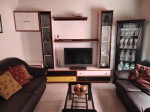 - un salon avec deux canapés et une télévision dans l'établissement Apartamento O Grove, à O Grove