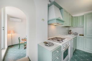 kuchnia z zielonymi szafkami i kuchenką górny piekarnik w obiekcie Casa Ventrosa, Anacapri w mieście Anacapri