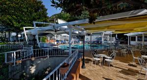 a swimming pool with chairs and tables and umbrellas at Villa Poseidon -Boutique Hotel- in Salerno