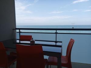 - une table avec des chaises et une vue sur l'océan dans l'établissement Fronte mare, à Marotta