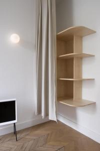 a room with shelves and a television on a floor at Les Toquées Maison d'hôtes in Lille