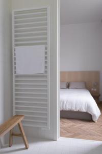 a white bedroom with a bed and a window at Les Toquées Maison d'hôtes in Lille