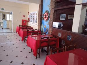 una fila de mesas y sillas rojas en un restaurante en Thetis Hotel Pousada, en Arraial do Cabo